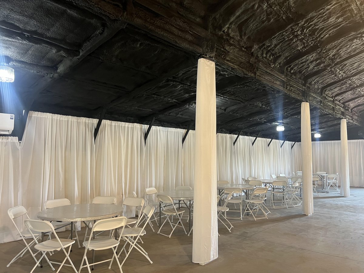 The venue interior, draped in white and set with tables and chairs